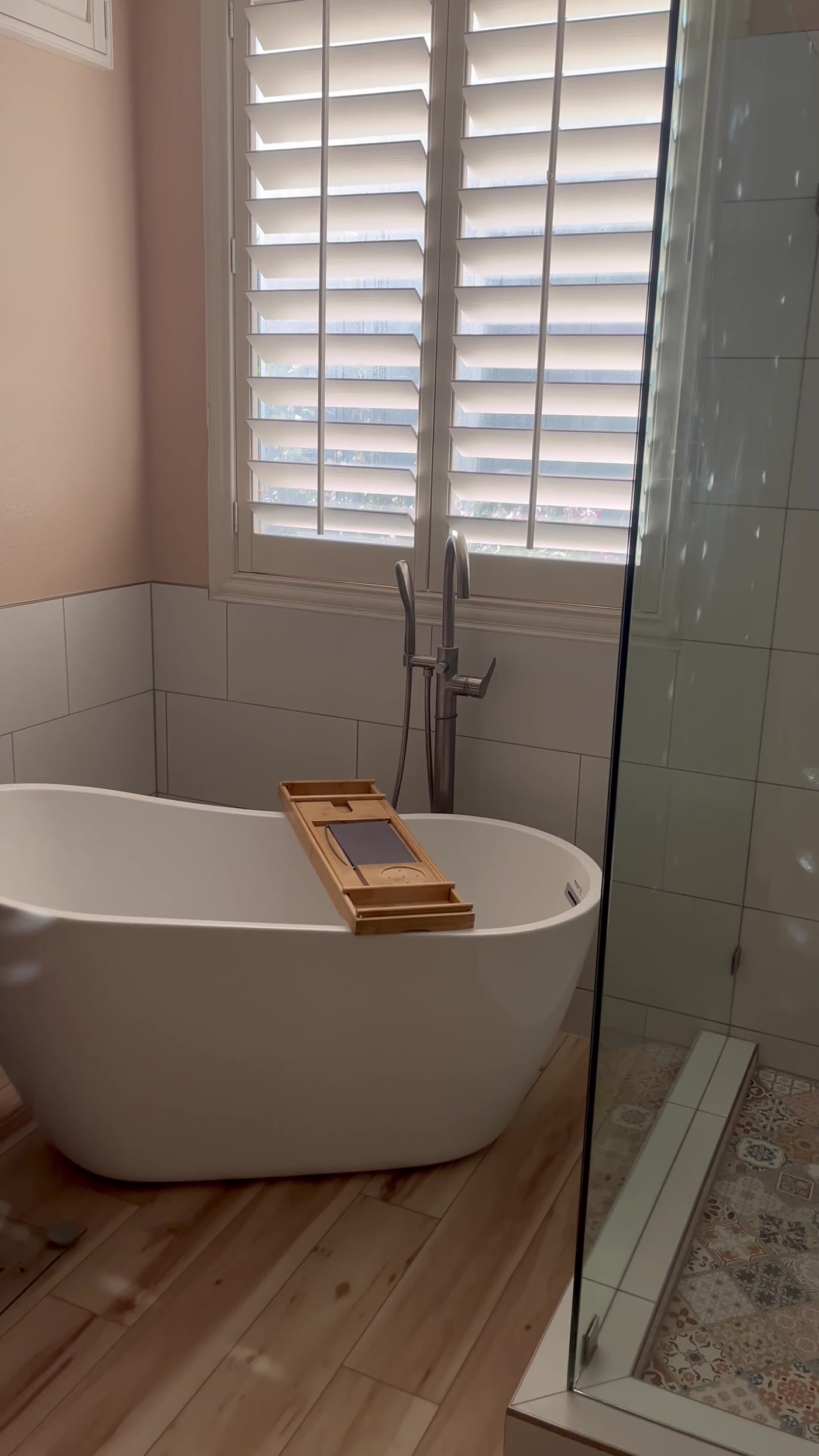 Walk-in shower with bench seat and patterned mosaic niche
